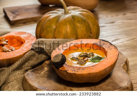 Cream of pumpkin soup with pumpkin seeds and and garlic croutons  in hollowed-out pumpkin. Shallow dof.