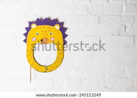 Bright cardboard mask on a white brick wall. Consept card. Hedgehog