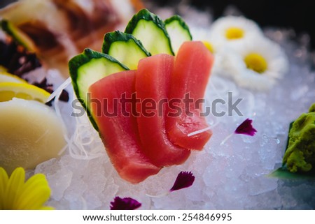 Tuna Sashimi - Maguro fresh raw tuna on Daikon White Radish. Garnished with Ginger, Wasabi, Seaweed, Cucumber, Salad Leaf and Lemon
