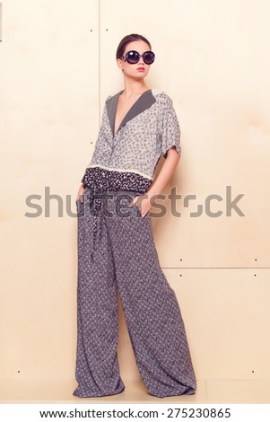 Full height portrait of a young woman in a bright pantsuit
