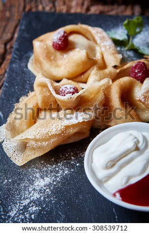 Crepes with raspberries with copy space on black background