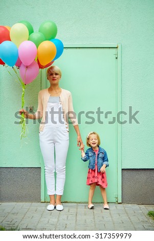 mother and child with colorful balloons mother and child with colorful balloons on green background