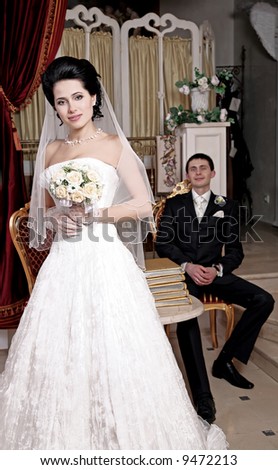 The bride costs in the foreground and smiles