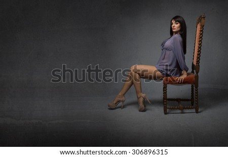 model sitting on a red chair, empty room
