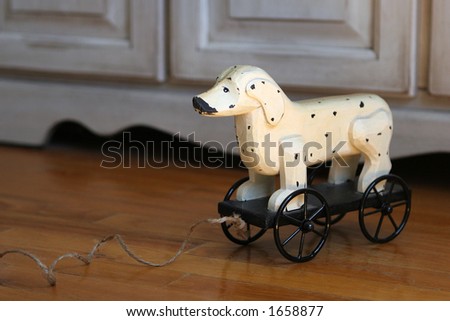 Child's wooden toy dog on wheels with pull string.