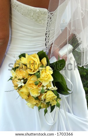 Detail of wedding dress back and yellow rose bouquet.