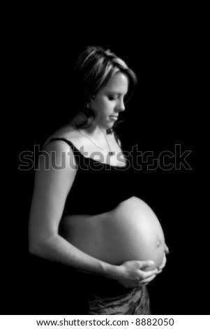 low-key black & white image of pregnant woman