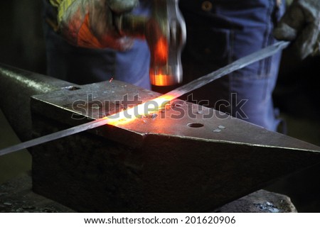 Blacksmith making sword in a forge of Toledo