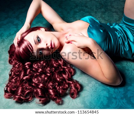 stunning woman with red hair and evening-dress lying on the floor