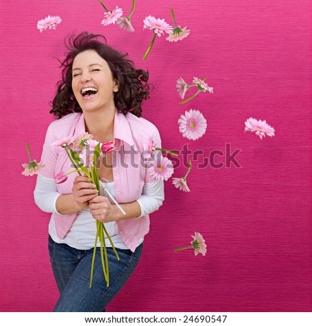 spring concept - playful girls with flowers and pink wall