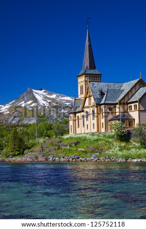 Picturesque Lofoten cathedral on Lofoten islands in Norway with snowy peaks in the background