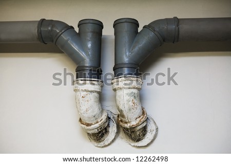Pipes for the water drain on a background of a wall