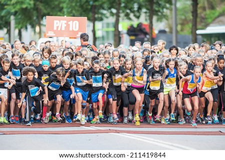 STOCKHOLM - AUG, 16: Closeup of the chaotic start when the young kids runs in the Midnight Run for children (Lilla Midnattsloppet) event. Aug 16, 2014 in Stockholm, Sweden