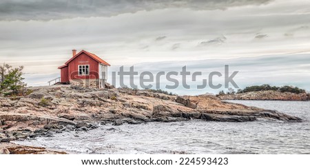 Red house at sea shore in the baltic sea in dull colors in autumn