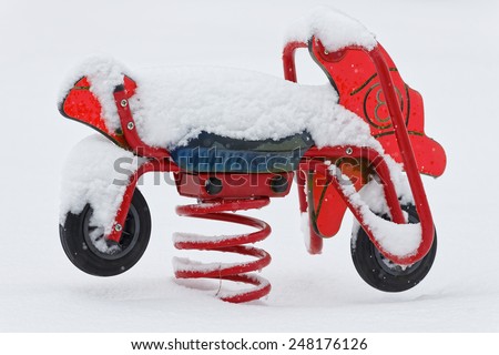 Snow covered toy motorcycle in a park during the winter, Sweden