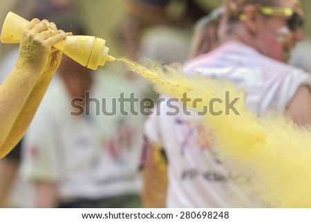 STOCKHOLM, SWEDEN - MAY 23: Volunteer spraying yellow paint at Stockholm Color Run in Tantolunden or Tanto on May 23, 2015. People from all walks of life participated in the run.