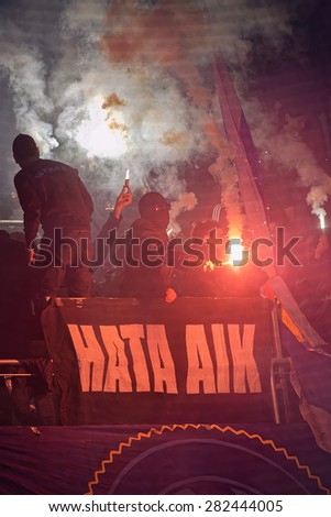 STOCKHOLM, SWEDEN - MAY 25: Ultras and masked people in halftime using bengal fires in the game between DIF vs AIK at Tele2 arena on May 25, 2015. Tele2 arena is a multipurpose arena.