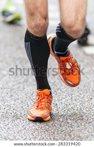 STOCKHOLM - MAY 30: Closeup of runners feet and legs in front view at the wet streets of Stockholm in ASICS Stockholm Marathon 2015.