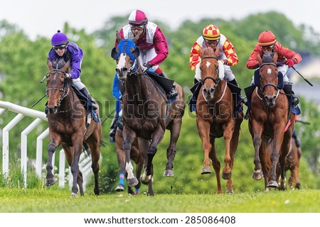 STOCKHOLM - JUNE 6: Group of jockeys and horses in fast pace during the race at the Nationaldags Galoppen at Gardet. June 6, 2015 in Stockholm, Sweden.