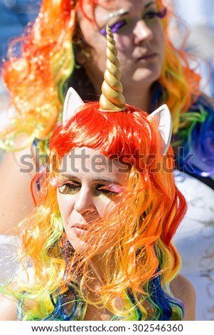 STOCKHOLM, SWEDEN - AUGUST 1, 2015: Girl in long rainbow hair and unicorn costume at the Pride parade in Stockholm. Approx 400.000 spectators at the streets.