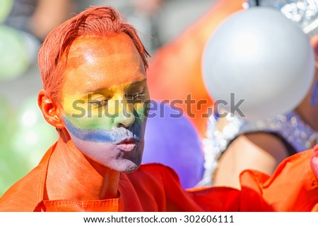 STOCKHOLM, SWEDEN - AUGUST 1, 2015: Colorful man with red hair and face in rainbow colors at the Pride parade in Stockholm. Approx 400.000 spectators at the streets.