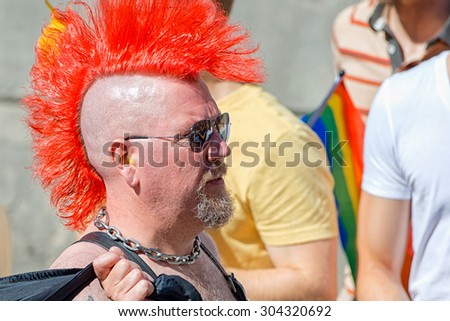 STOCKHOLM, SWEDEN - AUGUST 1, 2015: Man in profile with red mohikan at the Pride parade in Stockholm. Approx 400.000 spectators at the streets.