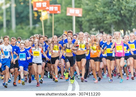 STOCKHOLM, SWEDEN - AUGUST 15, 2015: Runners just after the start at Lilla Midnattsloppet for runners aged 13. The track is 1775 meters and the runners are aged 8-15 years.