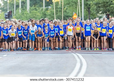 STOCKHOLM, SWEDEN - AUGUST 15, 2015: Starting field with nervous runners just before the start Lilla Midnattsloppet for runners aged 13. The track is 1775 meters and the runners are aged 8-15 years.