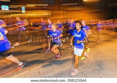 STOCKHOLM, SWEDEN - AUGUST 15, 2015: Female runners in colorful lights on the streets of Soder at Midnattsloppet or the Midnight run. The track is 10 km and goes thru the streets of Stockholm.