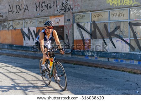 STOCKHOLM - AUG 23, 2015: Female triathlete on a bike in a curve at Slussen in the ITU World Triathlon event in Stockholm.