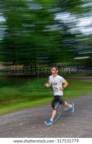 STOCKHOLM - SEP 16, 2015: Male runner in motion blur in forest at the event 5K EASD Run Walk to change diabetes at Stockholm Olympic Stadium with surroundings. 5000 meters for diabetes awareness.