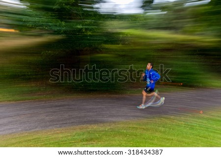STOCKHOLM - SEP 16, 2015: Runner in motion blur in forest at the event 5K EASD Run Walk to change diabetes at Stockholm Olympic Stadium with surroundings. 5000 meters for diabetes awareness.