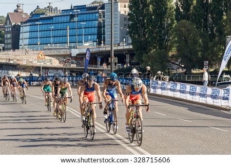 STOCKHOLM, SWEDEN - AUG 22, 2015: Group of male triathletes on bicycles at Slussen in the Men\'s ITU World Triathlon series event