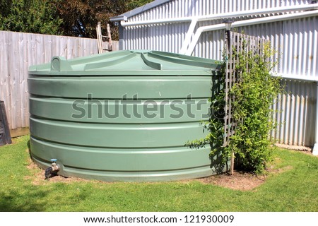 Large eco- friendly water storage tank in suburban backyard