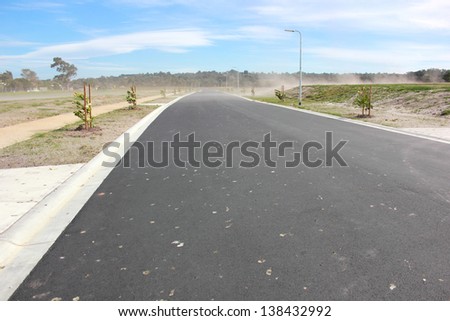 New road in new real estate subdivision in australia on a very windy day with dust blowing