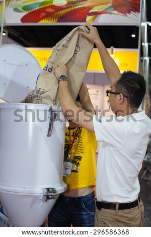 BANGKOK ,THAILAND - JULY 11: Unidentified people put a plastic  pellets in to injection machine at InterPlas Thailand 2015 , on  JULY 11, 2015 in Bangkok, Thailand.