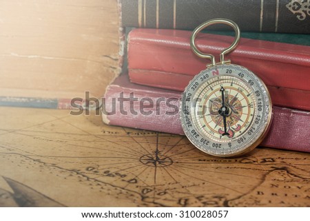 Vintage compass lies on an ancient map