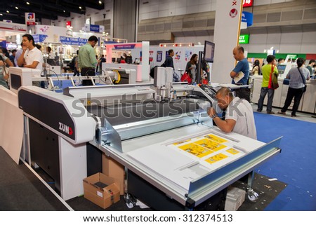 BANGKOK - AUGUST 29 :worker control cutting sticker machine at Pack Print and T-PLAS THAILAND on Aug 29,2015 in BITEC ,Bangkok, Thailand.