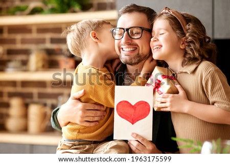 We love you, dad. Young happy father getting congratulations on Fathers Day from two excited kids at home, son and daughter, smiling children giving daddy handmade postcard and wrapped gift box