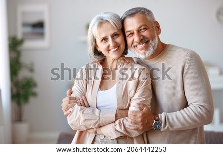 Similar – Image, Stock Photo Smiling couple embracing in forest sitting on tree roots