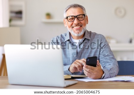 Similar – Image, Stock Photo Senior man using mobile phone on table near laptop