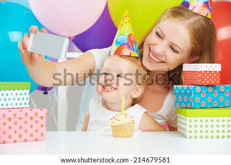 happy children\'s birthday. selfie. mother photographed  her daughter the birthday child with balloons, cake, gifts