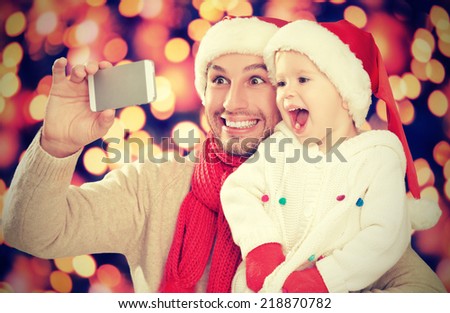 selfe  in Christmas. happy family dad playing with daughter and photographed on  mobile phone