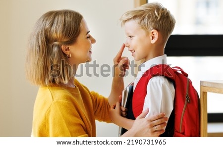 First day at school. Mother adjusts the briefcase to her happy son  during the  preparing   for school studies  at home Сток-фото © 