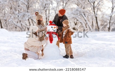 Similar – Image, Stock Photo Two children with Christmas or Santa Claus caps look arm in arm out the window and wait for Christmas