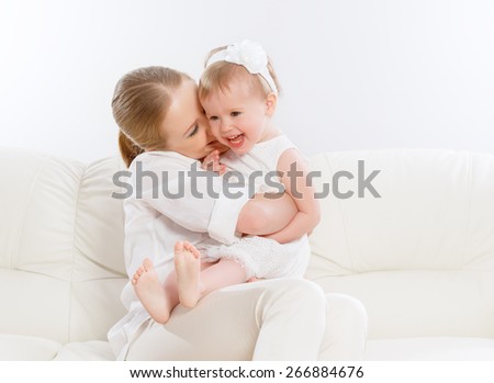happy family. Mother and baby daughter plays at home on the sofa