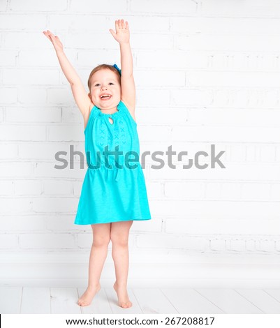 happy little girl raised her hands up and measure your height, shows that increased
