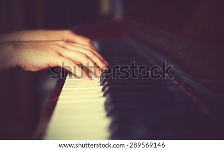 hands of a young woman pianist on the piano keyboard