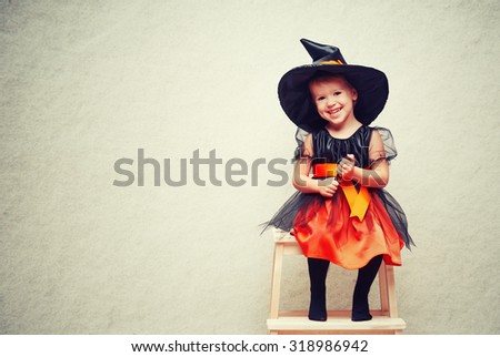 Halloween. cheerful little witch with a magic wand conjure and laughs.