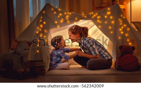 Photo of happy family mother and daughter playing at home in a tent 